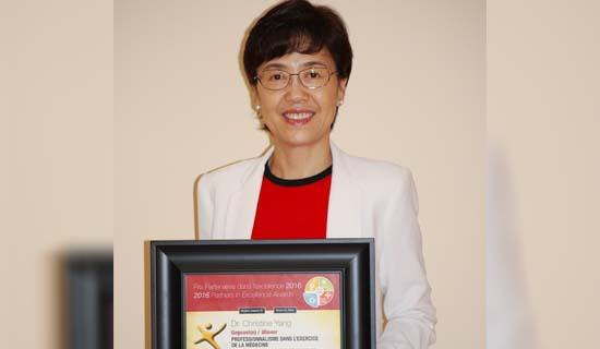 Dr. Yang holding her award