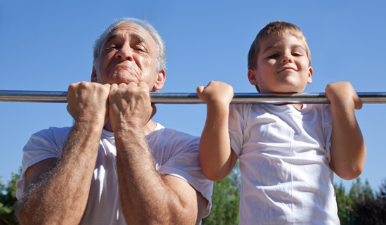 an senios man and young boy doing pull ups