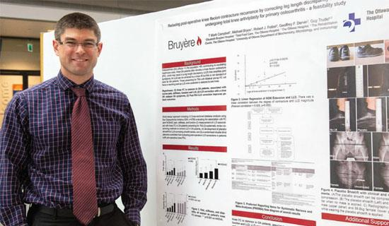 Mark Campbell stands next to his research poster