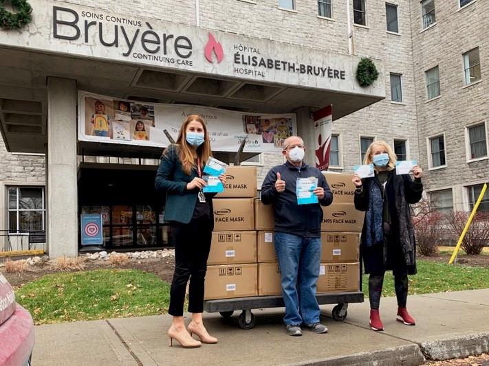 Bruyère Staff and Foundation Board Members accept masks in front of Élisabeth Bruyère Hospital