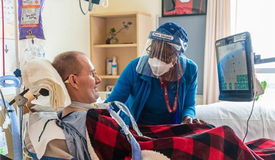 Nurse interacting with patient at bedside