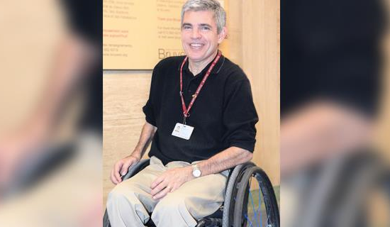 Kirby Kranabetter sitting in a wheelchair and smilling