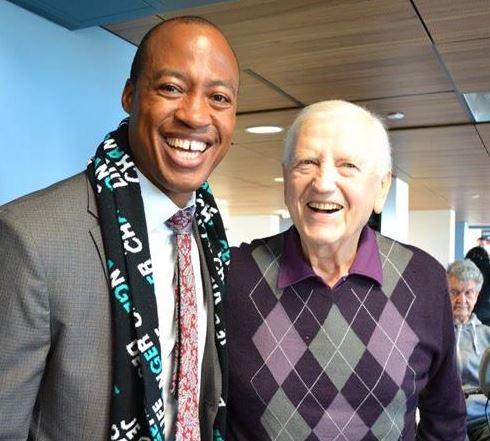 Henry Burris posing with an aging man