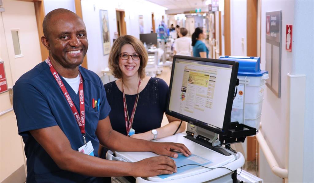 a male nure and a doctor smiling in a hospital hallway