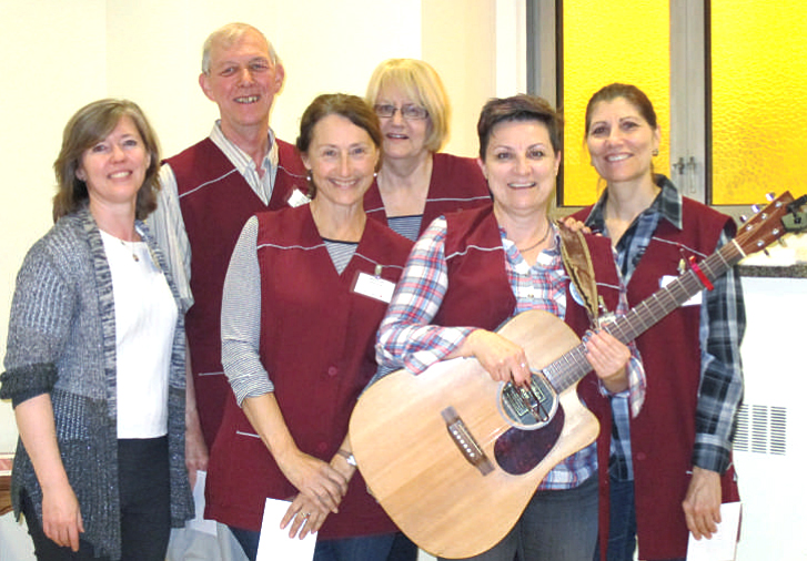 a groupe of bruyere volunteer holding a guitar
